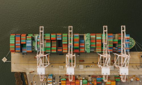 Overhead shot of colorful cargo containers and cranes at Baltimore's bustling port.